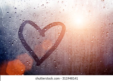 Autumn rain, the inscription on the sweaty glass - love and heart