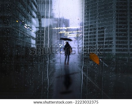  Autumn Rainy drops on window , couple man and woman  with umbrella silhouette reflection Modern buildings facade windows evening blurred light in glass business urban architecture