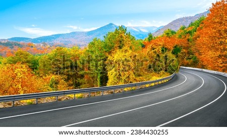 Autumn road landscape at sunset in beautiful colorful nature. Highway scenery among mountains in autumn season. Nature landscape on beautiful road in colorful fall. mountain road in autumn colors.