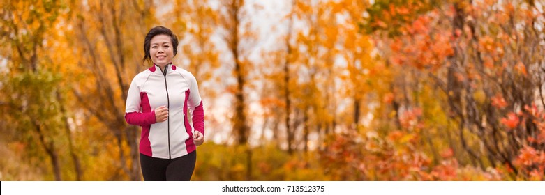 Autumn Running Middle Age Asian Woman Jogging In Park Banner Panorama. Active Lifestyle Mature Lady In Her 50s Living A Healthy Life.