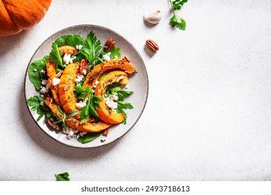 Autumn salad with grilled pumpkin, cottage cheese, pecan nuts and herbs on white background, top view, copy space. Seasonal autumn warm salad recipe, vegetarian comfort food. - Powered by Shutterstock