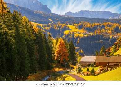 Autumn scenery of Dolomite Alps. Colorful hills and rocky mountains under picturesque sky. Alpine village Santa Cristina Val Gardena. It is a famous resort in the Dolomites, Italy