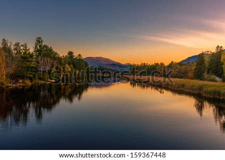Autumn scenery at sunset reflected in the water of the river