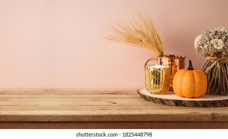 Autumn season concept with pumpkin, home decor and candle on wooden table. Halloween or Thanksgiving greeting card.