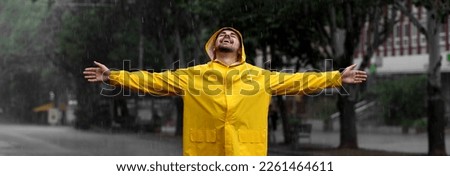 Autumn season. Happy young man in bright coat outdoors on rainy day. Banner design