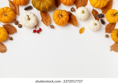 Autumn seasonal background from decorative pumpkins, dried foliage, pinecones and acorns top view. Thanksgiving day, harvest, autumn and fall concept top view.