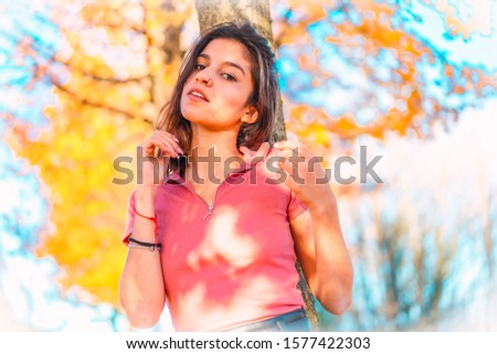 Autumn shooting, portrait of a pretty brunette with pink shirt. Looking at camera