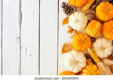 Autumn Side Border Of Pumpkins, Leaves And Natural And Fall Decor. Top Down View On A White Wood Background With Copy Space.