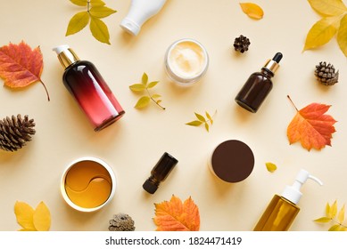 Autumn Skin Care products and autumn leaves on yellow background, flat lay, copy space.  Seasonal beauty routine and organic cosmetic concept.