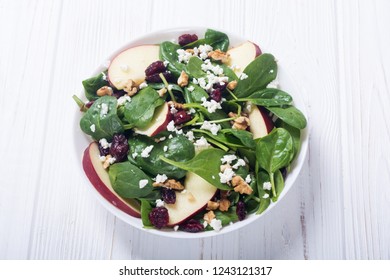 Autumn spinach salad with apple , cheese , walnut and dried cranberry . Healthy vegetarian food - Shutterstock ID 1243121317