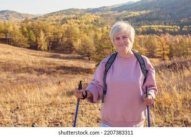 Autumn Sport - Nordic Walking. Mature Woman Hiking In Fall Forest. Active People Outdoors. Scenic Peaceful Landscape