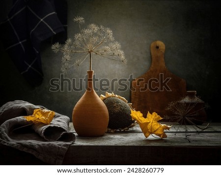 Autumn still life with a dry branch in a clay vase on a dark background.