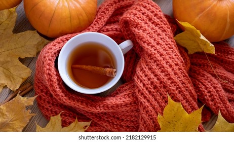 Autumn Still Life With Fragrant Cinnamon Tea, Scarf, Pumpkins And Yellow Maple Leaves. Fall Concept. Shallow Depth Of Field. Top View. Selective Focus. 