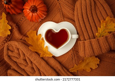 Autumn still life. Oak leaves, heart cup on knitted scarf or plaid. Concept of autumn resing time, romantic, hygge, unplug, mindfulness, Warm, cozy, rustic style home decor, copy space, banner