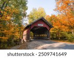 Autumn in Stowe Vermont Brookedale Covered Bridge Historic Red Wooden Roof Over Road Into Colorful Fall Foliage Forest on Bright October Day