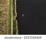 autumn sunny day by the river for fishing. a floating boat sails across the river and the other bank. landing craft. advertisement for fishing equipment. colorful leaves of trees in the alley