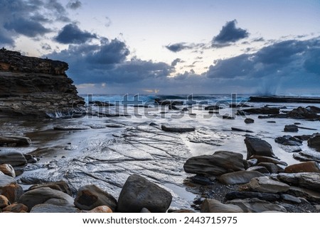 Autumn sunrise seascape with clouds and rocks at The Skillion in Terrigal, NSW, Australia.