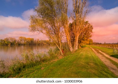 Autumn Sunset On A Waterway Of The Dordogne River Near A Vineyeard Near Bordeaux In France.