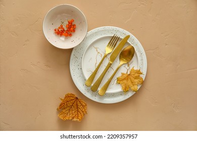 Autumn Table Setting With Fallen Leaves And Rowan On Beige Background