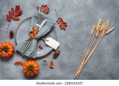 Autumn table setting on concrete gray background. Gray plate, cutlery and decorative pumpkins. Thanksgiving and harvest concept. Top view, flat lay. Selective focus - Powered by Shutterstock