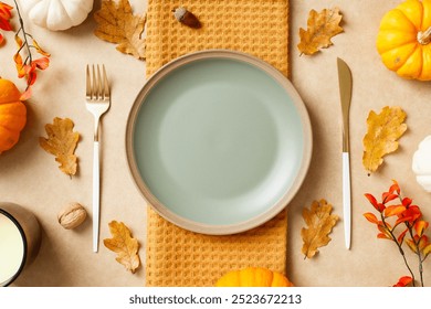 Autumn table setting with pumpkins, leaves, and an empty plate with cutlery. Thanksgiving, seasonal dining, fall holiday celebration concept. - Powered by Shutterstock