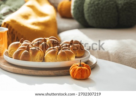 Autumn Table Setting with Pumpkin-Shaped buns with Cinnamon, Apples, Pumpkins, and Cozy Decor