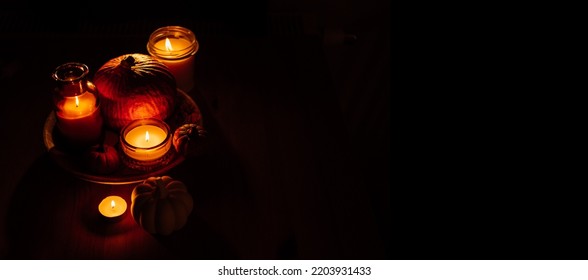 Autumn Thanksgiving Home Decor With Pumpkins And Burning Candles On Table. Dark Moody Banner Decorations With Pumpkin And Candles