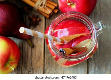 Autumn Themed Detox Water With Apple, Cinnamon And Red Pear In A Mason Jar Glass With Straw, Overhead View