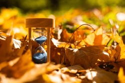 Autumn Time Theme, Sandglass On Fallen Leaves In Various Colors With Copy Space