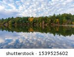 Autumn trees and clouds reflected in calm lake
