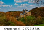 Autumn trees scene with Eltz Castle or Burg Eltz. Medieval castle on the hills above the Moselle River. Rhineland-Palatinate Germany.