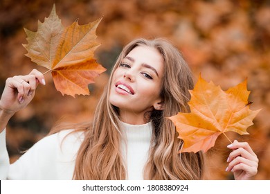 Autumn Trend. Beautiful Woman Fashion Model Having Fun In Fall Park Outdoors. Pretty Tenderness Model Looking At Camera