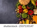 Autumn vegetable preparation dinner background. Food background with organic fresh farm raw veggies, pumpkin, corn, fruits, mushrooms, salad leaves, greenery, Ingredients for cooking with copy space.