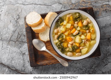 Autumn vegetarian Frantoiana soup with beans, potatoes, pumpkin, kale, carrots, onions and celery close-up in a bowl on the table. Horizontal top view from above
 - Powered by Shutterstock