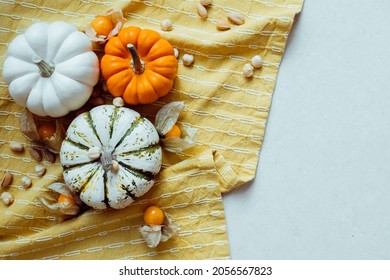 Autumn vibes. Top view of cozy fall background with cute pumpkins, nuts and physalis