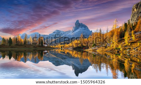  autumn view of  Lake Federa in Dolomites  at sunset. Fantastic autumn scene with colour sky, majestic rocky mount and colorful trees glowing sunlight in Dolomites. Location: Federa lake with Dolomite