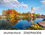 Autumn view with leaves turning Fall colors near the clock tower and pavilion along the Spokane River at Riverfront Park in downtown Spokane, Washington, USA.