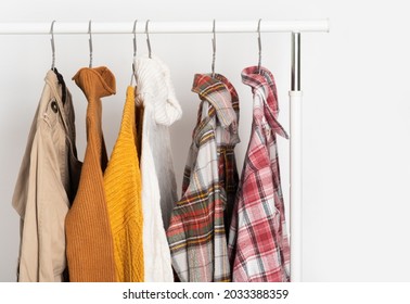 Autumn Vintage Clothing Hangs On Hangers On The Rack. Beige Trench Coat, Sweaters, Plaid Shirts. Organization Of Space, Winter Cleaning.