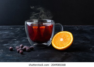 Autumn warming vitamin herbal tea with berries of black currants, garnished with orange, rosemary sprig, cinnamon stick and ginger - Powered by Shutterstock