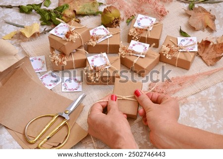 Autumn wedding favors making process woman hands crafting wrapping and decorating gift box with jute ribbon, artisan handmade small guest souvenirs, homemade presents fall rustic style decor