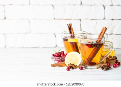 Autumn or winter hot tea with fruit, berries and spices in glass cup.