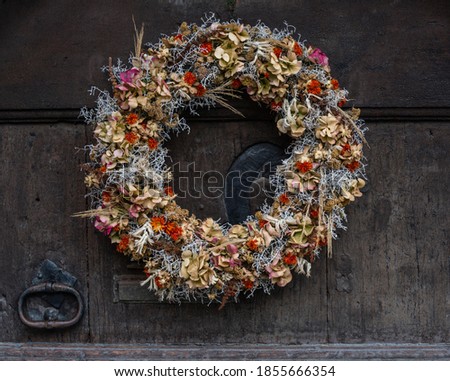 Autumn wreath with dreid flowers on an old wooden door.