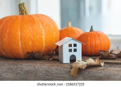 Autumnal Background. Toy house and pumpkin on wooden background. Thanksgiving banner copy space. Hygge mood, change of seasons concept. Hello Autumn with family Halloween party - Shutterstock ID 2186317225
