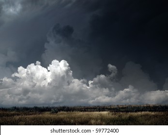 Autumnal Field Under Dark Thunderstorm Sky.