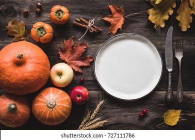 Autumnal Table Setting For Thanksgiving Dinner. Empty Plate, Cutlery, Pumpkins, Apples And Spices On Wooden Table. Fall Food Concept