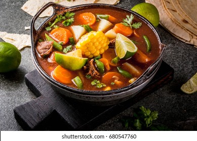 Autumnal vegetable stew. Mexican traditional vegetable soup Mole de olla with meat, potatoes, carrots, beans, corn and lime. Copy space