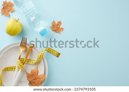 Autumnal weight loss and toning. Top view photo of plates, cutlery, water bottle, tape measure, fresh apple, fallen leaves on light blue background with promo space