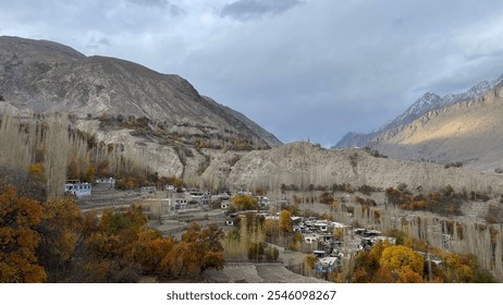 Autumn's Warmth Meets Winter's Chill: Vibrant hues beneath snowy Karakoram peaks, Ghanche District. Ghanche's seasonal splendor: Autumn meets snow-capped mountains - Powered by Shutterstock