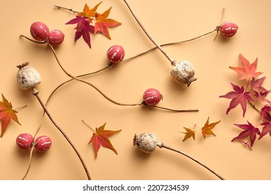Autumntime background with tiny orange pumpkins, red Autumn maple leaves and dry poppy pods, capsules . Flat lay, top view on orange paper. Monochromatic cream and orange Fall simple minimal backdrop.