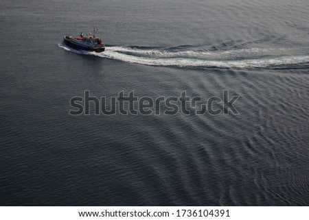 Auxiliary vessels of technical services. Pilot boat on the background of the water surface of the Persian Gulf.